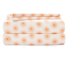 an orange and white sheet set with sunbursts on the top, in front of a white background