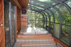 the inside of a house with an enclosed porch and hot tub on the side walk