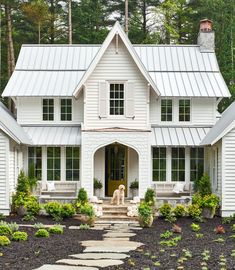 a white house with a dog sitting on the front porch and steps leading up to it