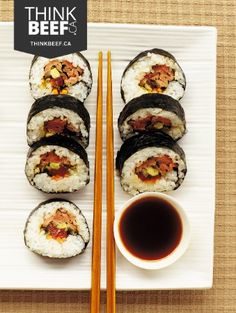 sushi and chopsticks on a white plate with a black label that says think beef