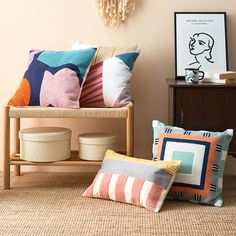 some pillows are sitting on the floor in front of a wall with a clock above it