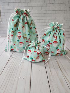 two bags with santa claus and snowmen on them sitting on a wooden floor next to a brick wall