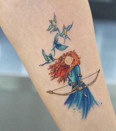 a woman with red hair and blue dress holding a bow tattoo on her left leg