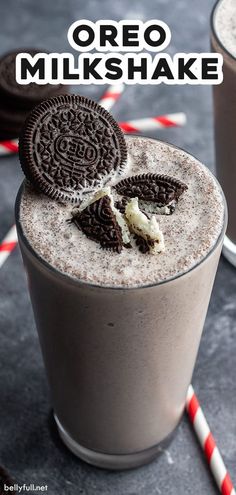 an oreo milkshake is in a glass with two cookies on the side