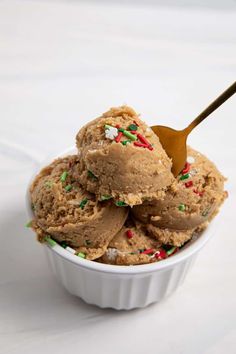 two scoops of ice cream in a bowl with sprinkles and candy canes