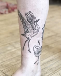 a tattoo on the leg of a person with a bird and snake in it's legs