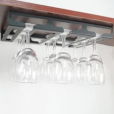 several wine glasses are lined up in a row on a shelf above the counter top