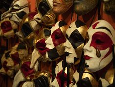 many masks are hanging on the wall in front of each other with different colors and patterns