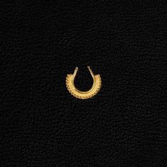 a gold earring on a black background