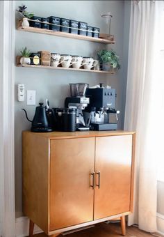 a wooden cabinet with some coffee cups on it