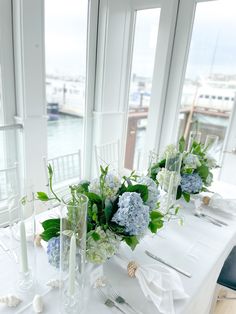 the table is set with white and blue flowers