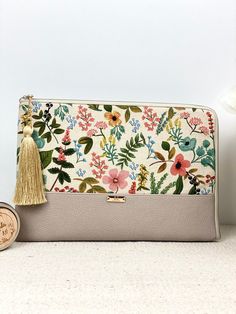 a white purse with flowers on it next to a small wooden box and a coin