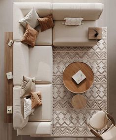 an overhead view of a living room with couches, tables and pillows on the floor