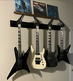 three electric guitars hanging on a wall