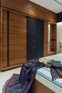 a bed sitting in a bedroom next to a wooden closet and mirror on the wall