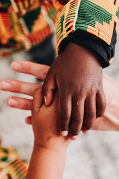 two hands holding each other in front of a person's face and the other hand