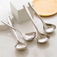 three silver spoons sitting next to each other on a table