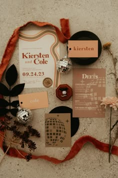 the wedding stationery is laid out on the floor with flowers and other things to do