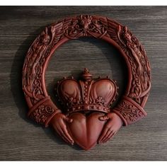 an ornately carved wooden wall hanging with a crown on it's back end