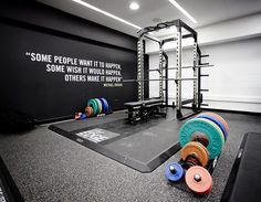 an empty gym with several different colored dumbs on the floor and some exercise equipment in front of it