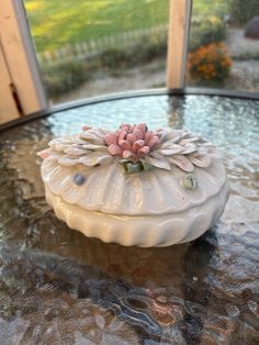 a white vase sitting on top of a glass table