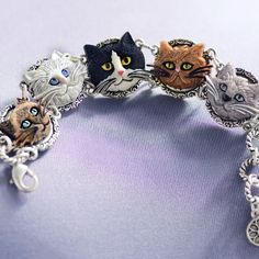 Five faces of wonderful cats adorn this bracelet. They are molded for detail and dimension, hand painted and mounted on the panels of our link bracelet. Adjustable to fit 7 to 8 wrists, the bracelet has a burnished silver finish, is lightweight and easy to clasp. So irresistible, you may want to adopt a litter of 6 to spread love and awareness. You know you're a cat person if you can identify each face on this bracelet as some feline you've known or loved or helped. And, for every bracelet we se Cat Memorial Jewelry, Lady Cat, Tom Y Jerry, Cat Faces, Lovers Bracelet, Cat Bracelet, Gift For Cat Lover, Silver Link Bracelet, Lovers Necklace