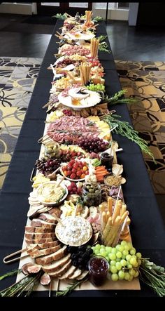 a long table filled with lots of different types of food on top of each other