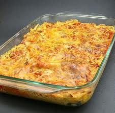 a casserole dish with meat and cheese in it sitting on a black table