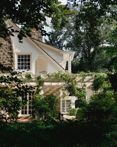 a white house surrounded by trees and bushes