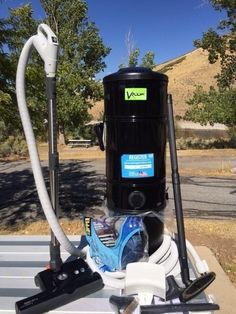 a black vacuum is sitting on top of a table next to other cleaning supplies and tools