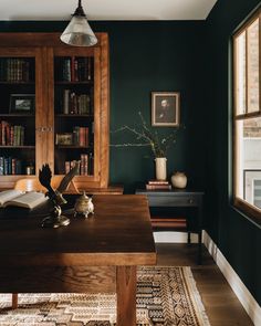 an open book sits on top of a wooden table in front of a bookshelf