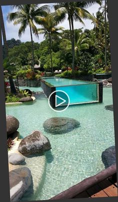 an outdoor swimming pool surrounded by palm trees and water features a stone path leading up to it