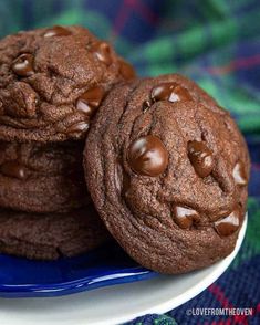 three chocolate cookies on a blue and white plate