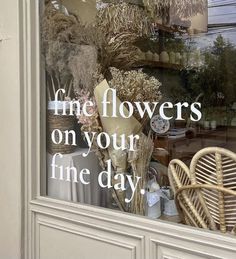 there is a window display with flowers in the front and behind it that says, fine flowers on your fine day