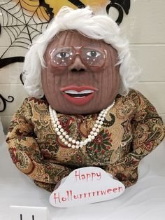 an old woman with glasses holding a happy halloween sign