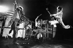 the rolling stones performing on stage in front of an electric guitar player and bandleader