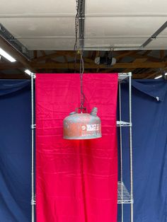 a red and blue tarp hanging from the ceiling next to a metal light fixture