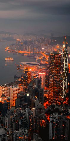 an aerial view of a city at night with the lights on and buildings lit up