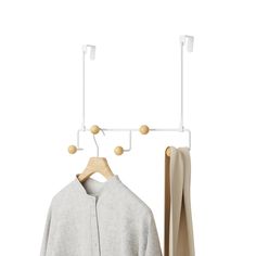 a coat rack with two coats hanging from it's hooks and an open jacket hanger