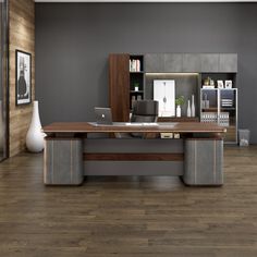 an office with wood flooring and gray walls, along with a large wooden desk