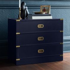 a blue dresser with two drawers and a candle on top