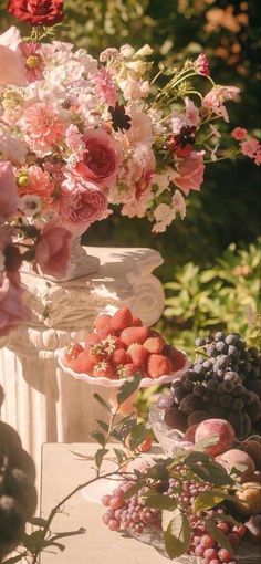 a table topped with lots of different types of fruits and flowers next to each other