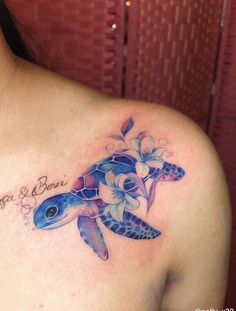 a woman with a tattoo on her chest has a blue turtle and flowers in it