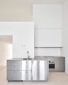 a kitchen with stainless steel appliances and white walls