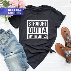 a t - shirt that says straight outa my twenties next to sandals and flowers