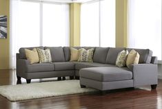 a living room with a sectional couch and pillows