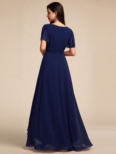 a woman in a long blue dress with short sleeves and a pleaed waistline