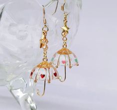 Name: Fashion Earrings for red peach umbrella Material: 14k Gold, gutta percha, color paint The umbrella can't close. Style: A: Pink blue, fishhook, B: Red, fishhook C: Gold, fishhook D: Pink blue, ear clip E: Red, ear clip F: Gold, ear clip Style: the umbrella will be used when it rains. The raindrop falls on the transparent umbrella. The rain is moist, gentle and refreshing, which makes people want to be close. The transparent umbrella represents the girl's purity and kindness, and the colorful heart represents the colorful inner world. This is an umbrella for the soul. Craft: not glass, not plastic. More beautiful than glass and plastic, more lightweight, better texture. Please contact me if you have any questions. Interesting Earrings, Umbrella Earrings, Birthday Dream, Beaded Fish, Crazy Earrings, Transparent Umbrella, Journaling Supplies, Clothing Aesthetic, Red Peach