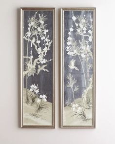 two framed pictures with white flowers in them on the wall next to each other,