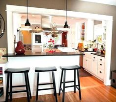 a kitchen with three stools in front of an island